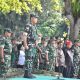 Personel TNI bersama masyarakat membersihkan eceng gondok dari permukaan Danau Tondano menggunakan alat manual dan perahu tradisional.