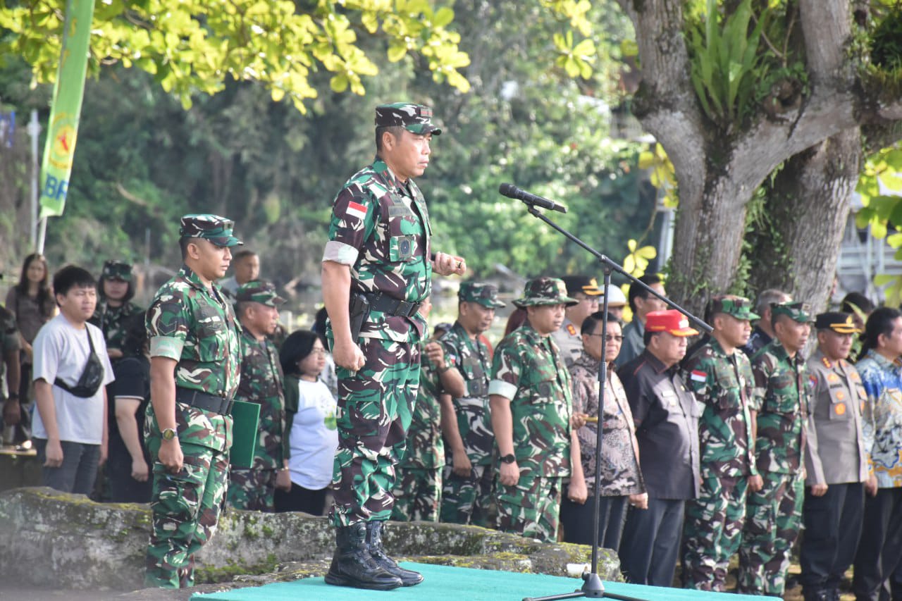 Personel TNI bersama masyarakat membersihkan eceng gondok dari permukaan Danau Tondano menggunakan alat manual dan perahu tradisional.