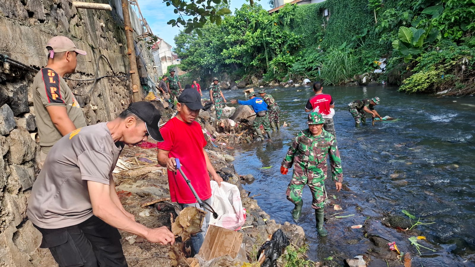 Personel TNI Kodim 1309/Manado bersama warga dan instansi pemerintah membersihkan sampah dari aliran Sungai Sario di sekitar Pasar Pinasungkulan.