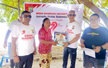 Jurnalis Polda Sulut menyerahkan paket sembako kepada nelayan di Desa Bukit Tinggi dalam rangka Hari Bhayangkara ke-79, Jumat 27 Juni 2025.