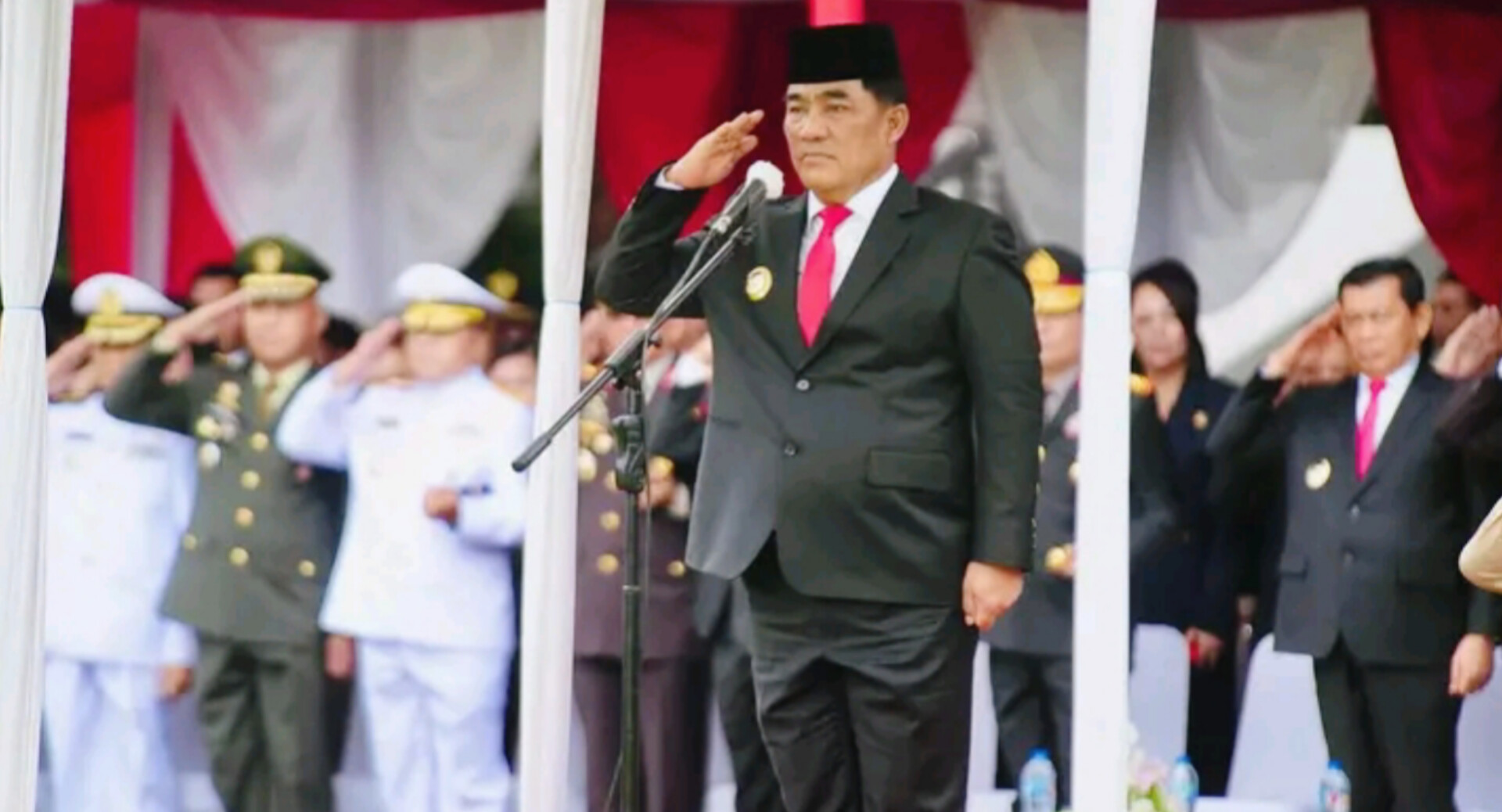 Gubernur Sulawesi Utara Yulius Selvanus berpidato di lapangan upacara yang basah oleh gerimis.