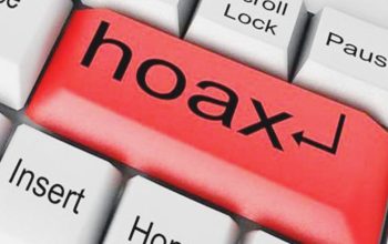 Ilustrasi jari menunjuk berita bohong di layar ponsel