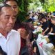 Presiden Joko Widodo tersenyum dan melambaikan tangan kepada warga saat menyapa dari halaman rumahnya di Solo, tengah menjalani pemulihan dari alergi kulit.