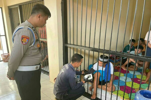 Petugas medis Polres Kotamobagu memeriksa kondisi kesehatan tahanan di ruang tahanan sebagai respons cepat atas keluhan sakit.