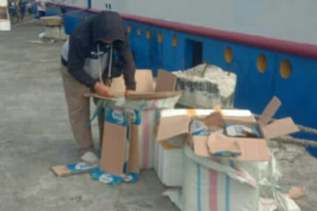 Petugas Polres Talaud memeriksa dus berisi ratusan botol cap tikus hasil penyelundupan dari kapal penumpang di Pelabuhan Lirung.
