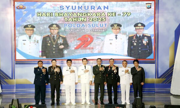 Gubernur Sulut Yulius Selvanus Komaling memotong tumpeng pada syukuran Hari Bhayangkara ke-79 di Aula Mapalus.