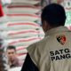 Petugas Satgas Pangan Polri memeriksa tumpukan beras dalam penyelidikan produsen nakal.
