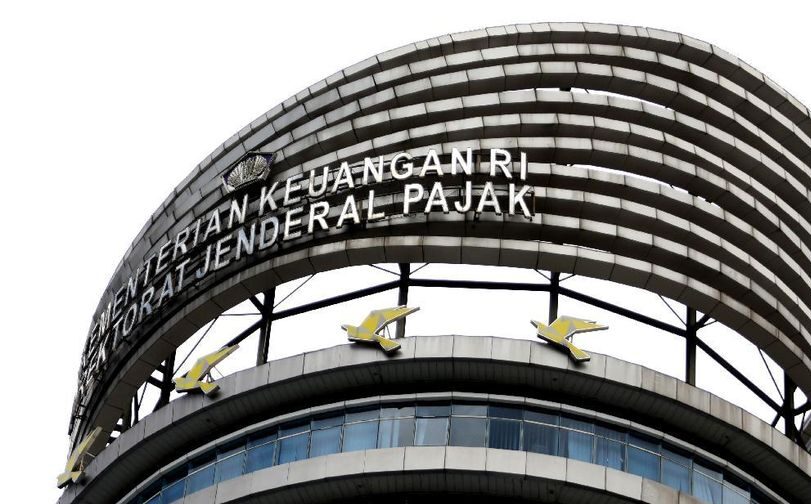 Petugas DJP sedang memantau unggahan media sosial melalui komputer, mengawasi konten pajak menggunakan teknologi crawling dan data analytics.