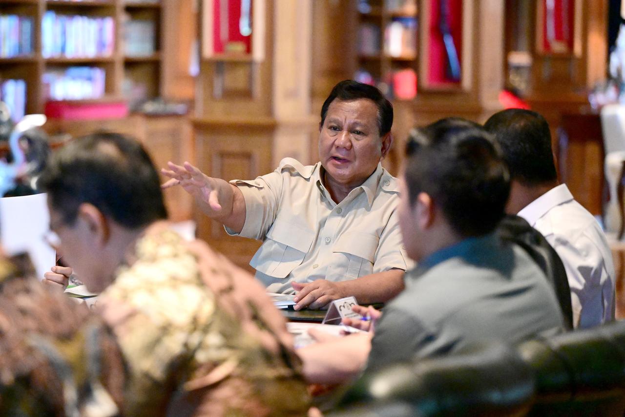 Prabowo Subianto memimpin rapat investasi, latar peta Indonesia dan simbol industri hilirisasi nasional.
