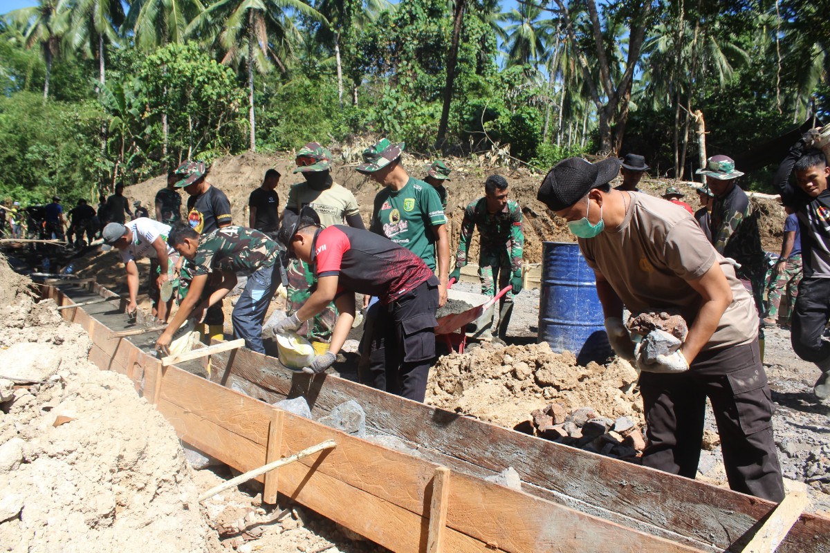 Personel TNI dan Polri bergotong-royong dalam pembangunan jalan desa dalam program TMMD ke-125 Kodim 1309/Manado.