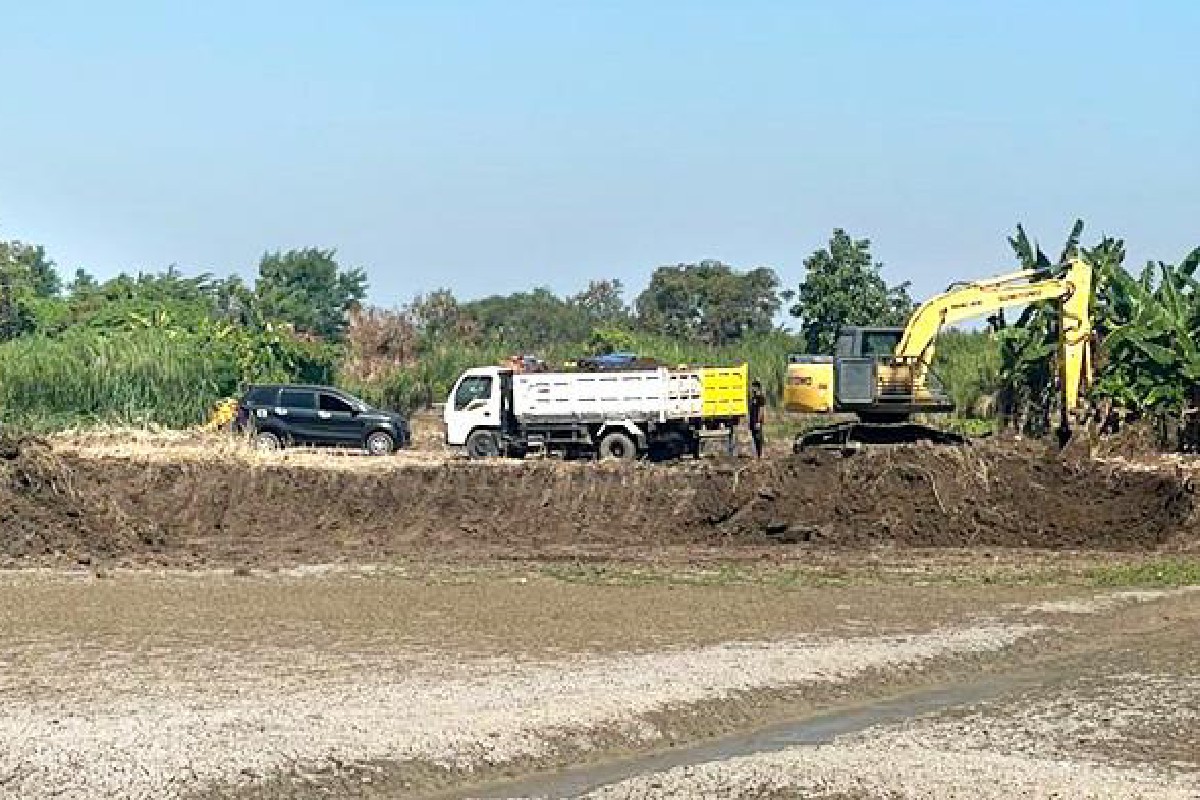Petugas Polres Gresik saat mengamankan alat berat dari lokasi tambang ilegal di tepi Sungai Bengawan Solo, Desa Sukorejo, Gresik.