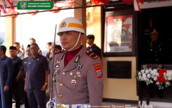 Kapolsek Sangtombolang Iptu Billygrehem Polii mengikuti prosesi pemindahan dan persemayaman Bendera Merah Putih di Bolaang Mongondow.