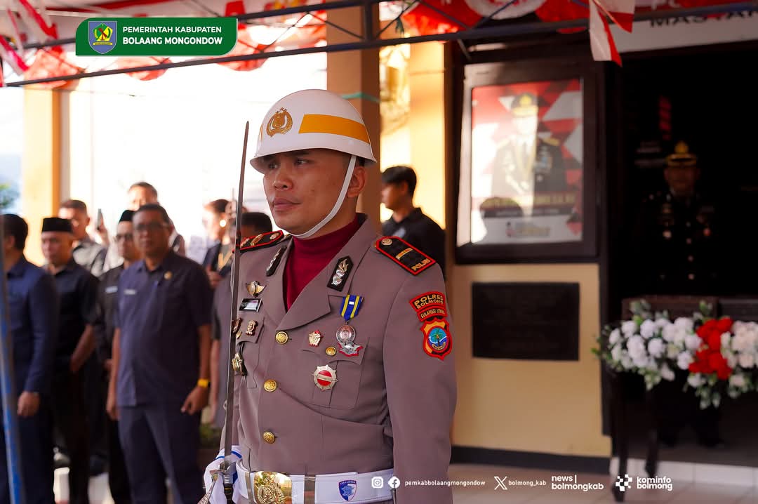 Kapolsek Sangtombolang Iptu Billygrehem Polii mengikuti prosesi pemindahan dan persemayaman Bendera Merah Putih di Bolaang Mongondow.